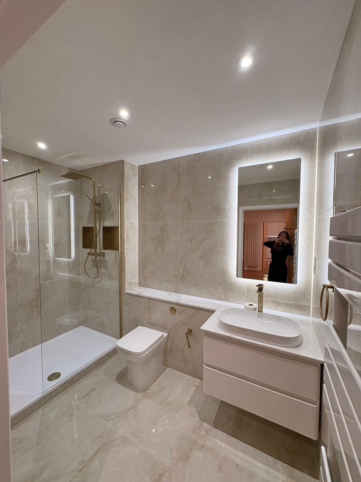 Walk-in shower with brass fittings and marble-effect tiling